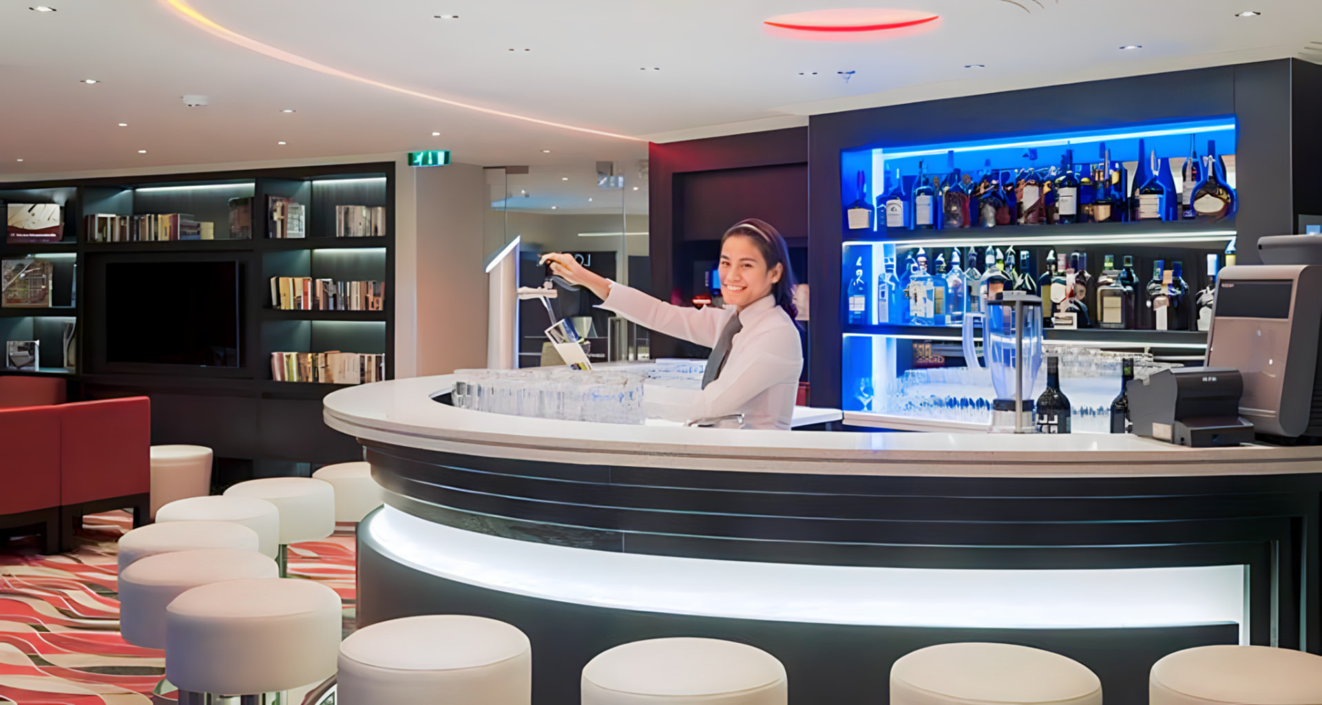 A bartender mixing drinks at the ship's curved lounge bar