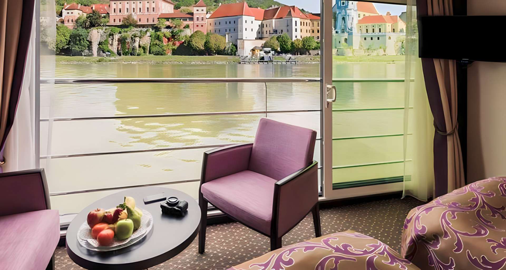A stateroom window opening onto a riverside village
